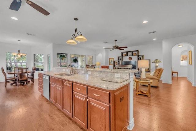 kitchen with a sink, visible vents, arched walkways, and ceiling fan