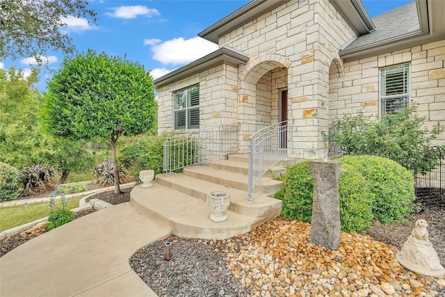 property entrance with stone siding and roof with shingles