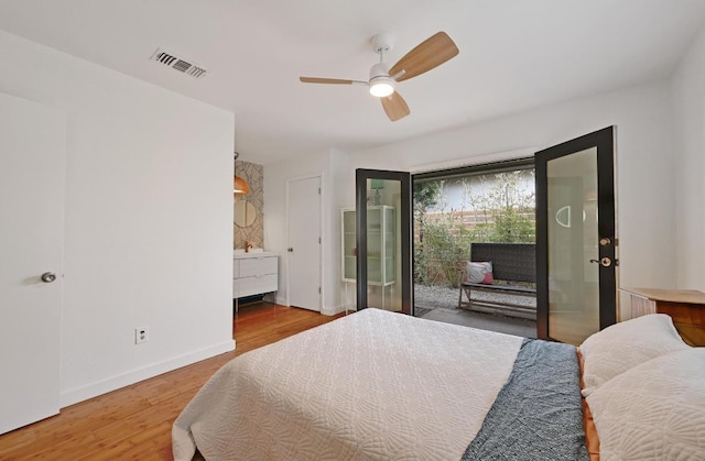 bedroom with access to exterior, visible vents, ceiling fan, baseboards, and wood finished floors