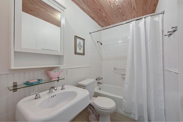 bathroom with a sink, shower / bath combination with curtain, wainscoting, wooden ceiling, and toilet