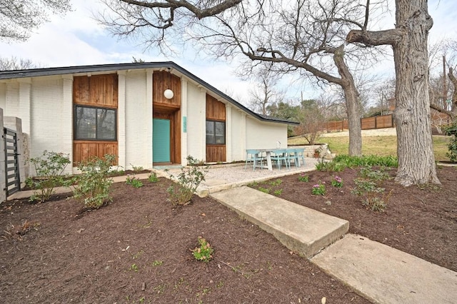 exterior space featuring brick siding and fence