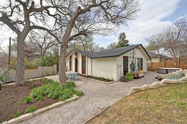 exterior space with a patio area, a fenced backyard, brick siding, and roof with shingles