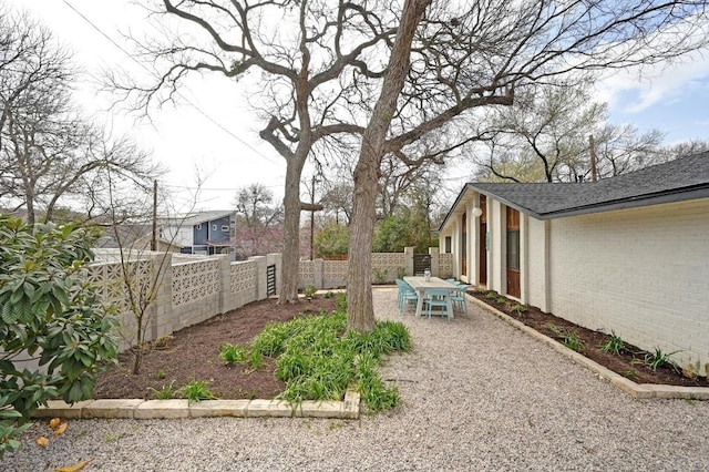 view of yard with a patio, a fenced backyard, and outdoor dining space