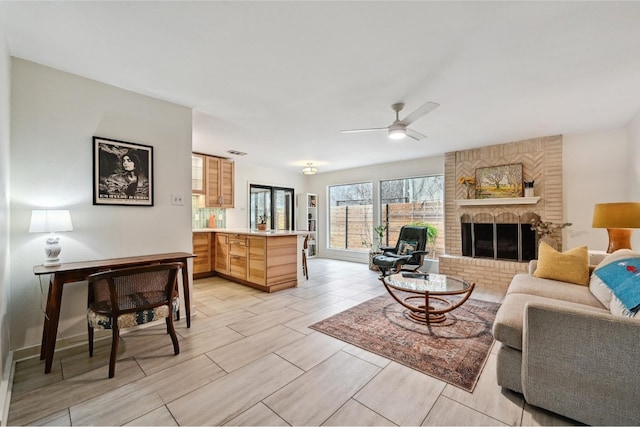 living room featuring a fireplace, ceiling fan, and wood tiled floor