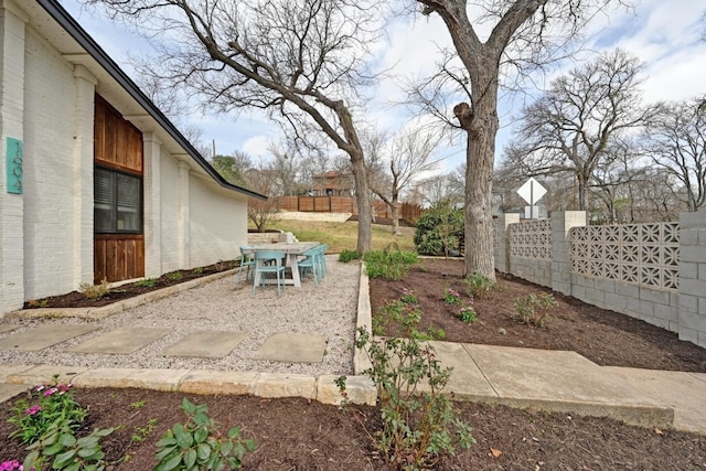 view of yard featuring outdoor dining space, a patio area, and fence