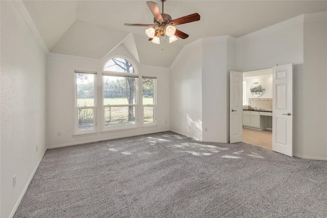 interior space with vaulted ceiling, light colored carpet, ceiling fan, and ornamental molding