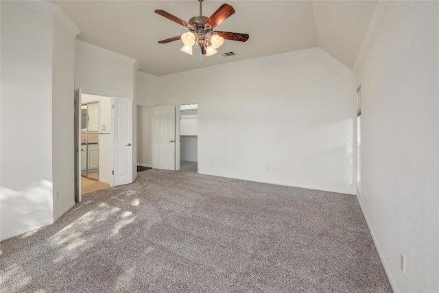 unfurnished bedroom featuring a spacious closet, connected bathroom, crown molding, lofted ceiling, and carpet flooring