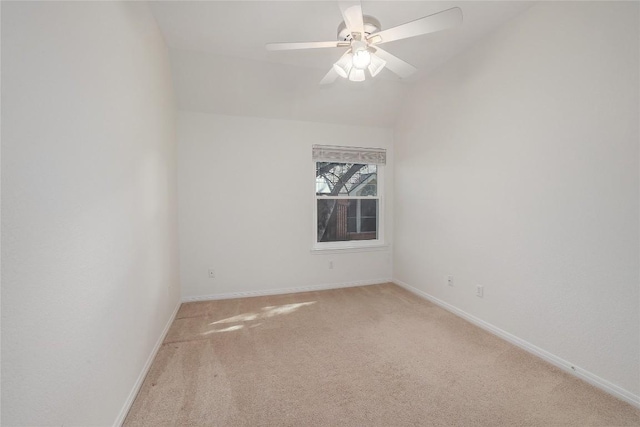 unfurnished room with ceiling fan, vaulted ceiling, baseboards, and light carpet