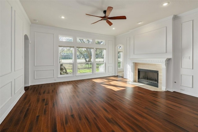 unfurnished living room with a decorative wall, a ceiling fan, and hardwood / wood-style flooring