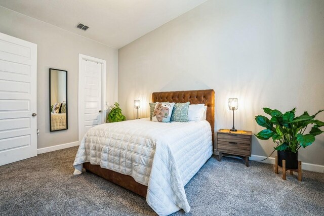 bedroom with baseboards, visible vents, carpet floors, and lofted ceiling