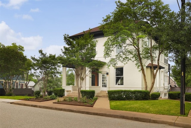 view of front of property with stucco siding and a front yard