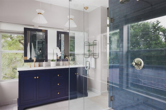 full bathroom with double vanity, baseboards, a stall shower, and a sink