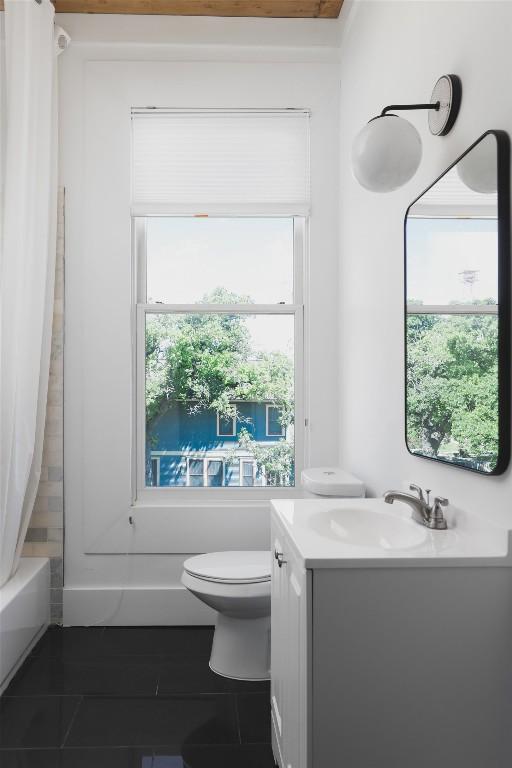 bathroom with shower / tub combo, toilet, and vanity