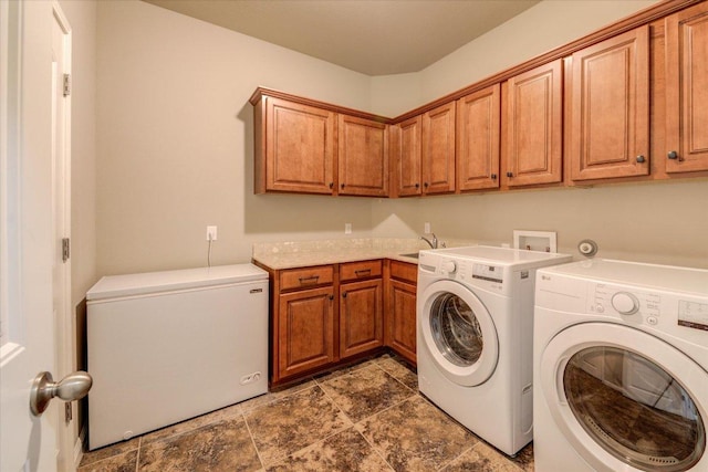 clothes washing area with a sink, cabinet space, and independent washer and dryer