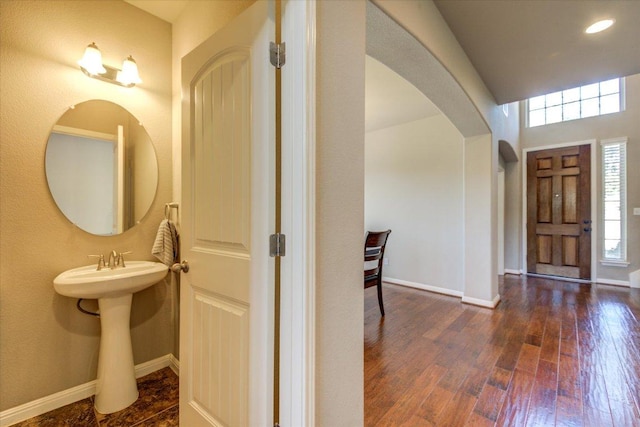 entrance foyer featuring hardwood / wood-style flooring, recessed lighting, baseboards, and arched walkways