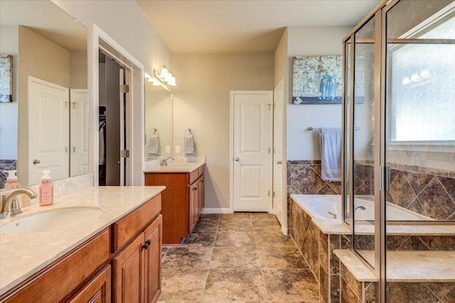 bathroom featuring a sink, a garden tub, two vanities, and a shower stall