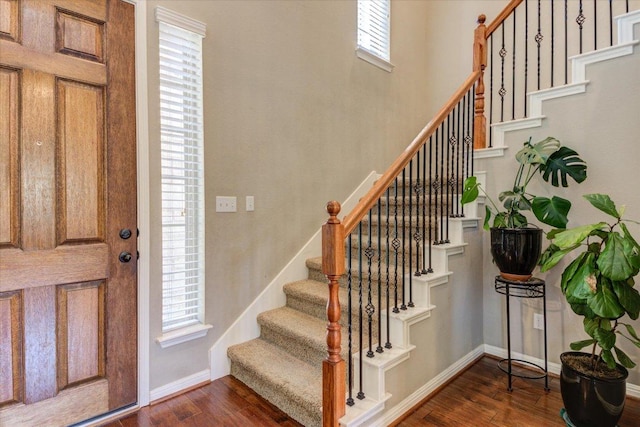 entryway featuring stairs, dark wood-style floors, and baseboards