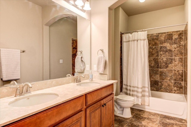 full bathroom featuring a sink, shower / bathtub combination with curtain, toilet, and double vanity