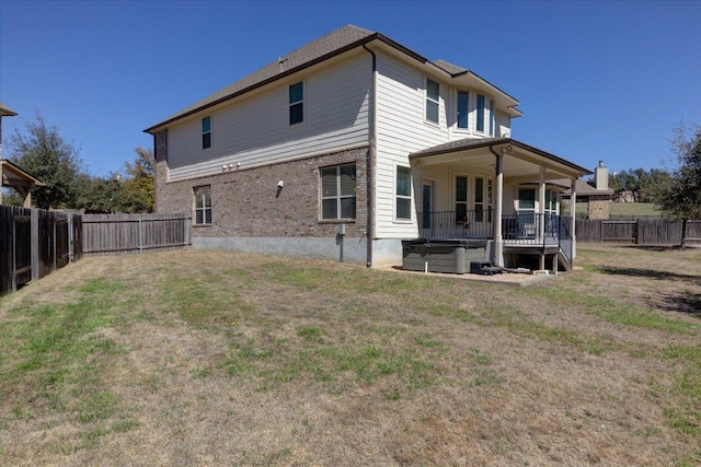 back of property with a fenced backyard and a lawn