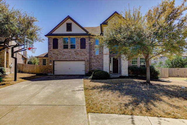 traditional home with fence, a garage, and driveway