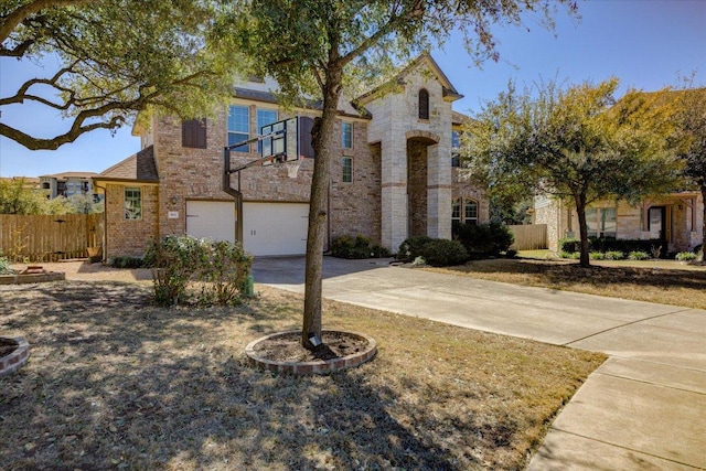 view of front of house with an attached garage, fence, brick siding, and driveway