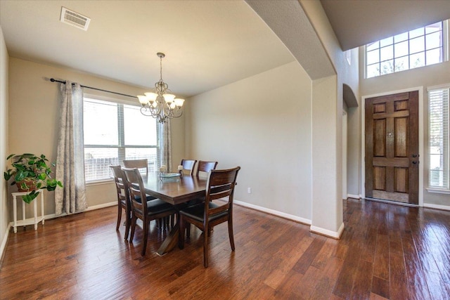 dining room with visible vents, baseboards, dark wood-style floors, an inviting chandelier, and arched walkways