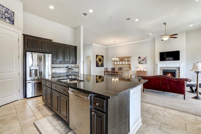 114 Angela Rose Ct, Austin, TX 78737 - kitchen with appliances with stainless steel finishes, a sink, ceiling fan, a lit fireplace, and a center island with sink
