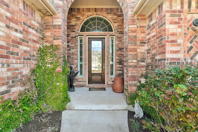 doorway to property with brick siding