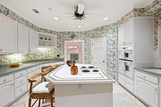 5315 Valburn Cir, Austin, TX 78731 - kitchen with wallpapered walls, light tile patterned floors, crown molding, white cabinets, and a center island