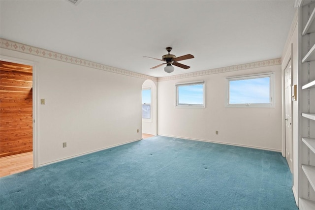 carpeted empty room with baseboards and ceiling fan