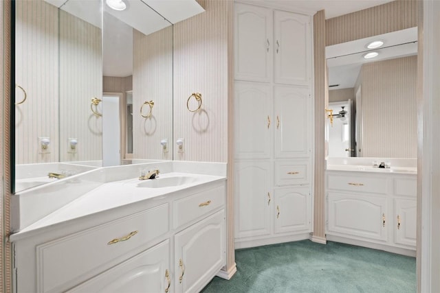 full bathroom featuring wallpapered walls and vanity