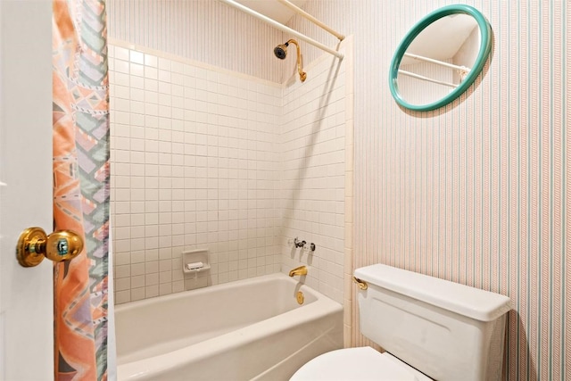 bathroom with wallpapered walls, toilet, and shower / bath combo