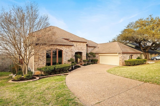 view of front of property featuring a front lawn, a tiled roof, a garage, and driveway