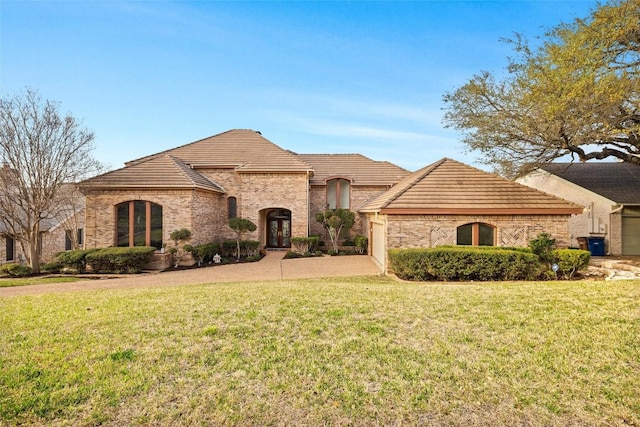 french country home featuring a front lawn and a tile roof