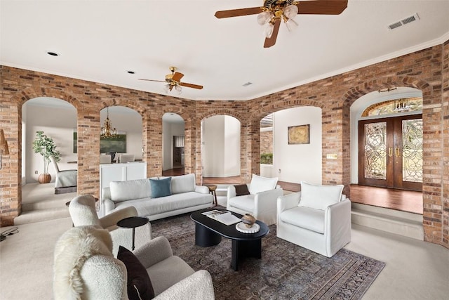 5315 Valburn Cir, Austin, TX 78731 - carpeted living area featuring arched walkways, ceiling fan, french doors, brick wall, and decorative columns