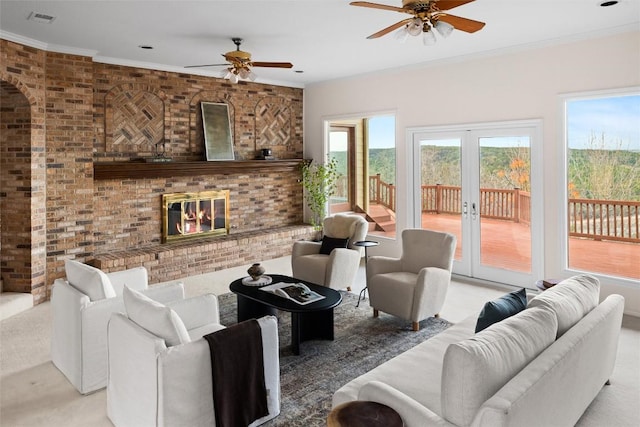 living room featuring crown molding, a fireplace, visible vents, and ceiling fan