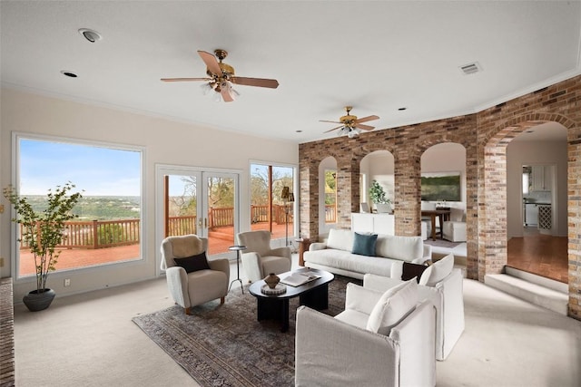 living room featuring arched walkways, visible vents, a ceiling fan, and carpet floors