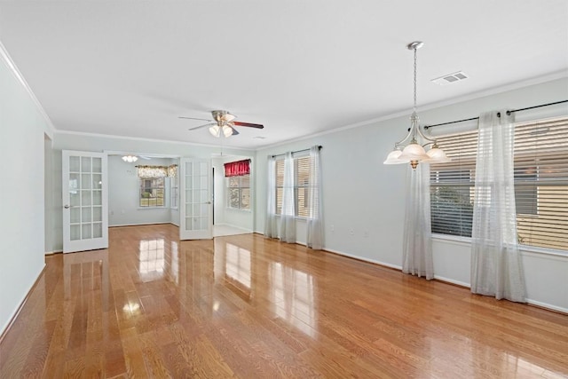 interior space with visible vents, french doors, a ceiling fan, and wood finished floors