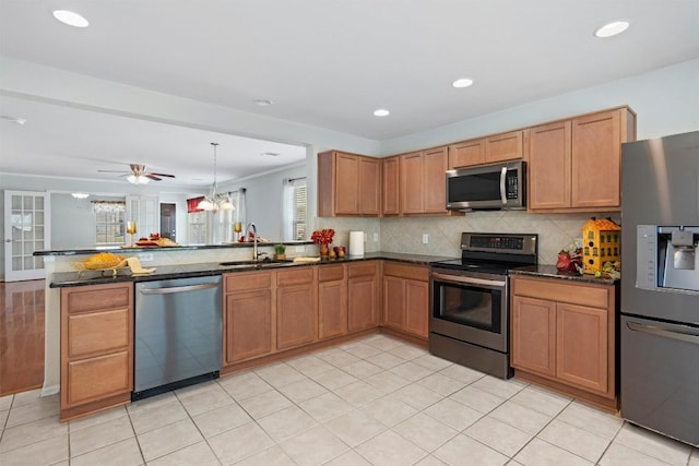 kitchen featuring dark stone countertops, stainless steel appliances, tasteful backsplash, and a peninsula