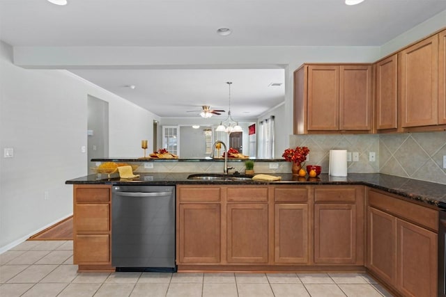 kitchen with stainless steel dishwasher, decorative backsplash, brown cabinets, and a sink