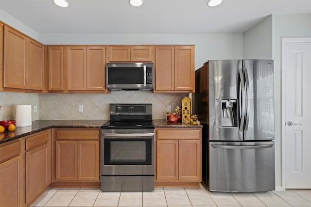 kitchen with dark stone counters, light tile patterned flooring, recessed lighting, appliances with stainless steel finishes, and tasteful backsplash