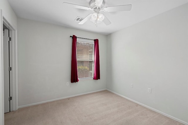 spare room with light carpet, visible vents, baseboards, and ceiling fan