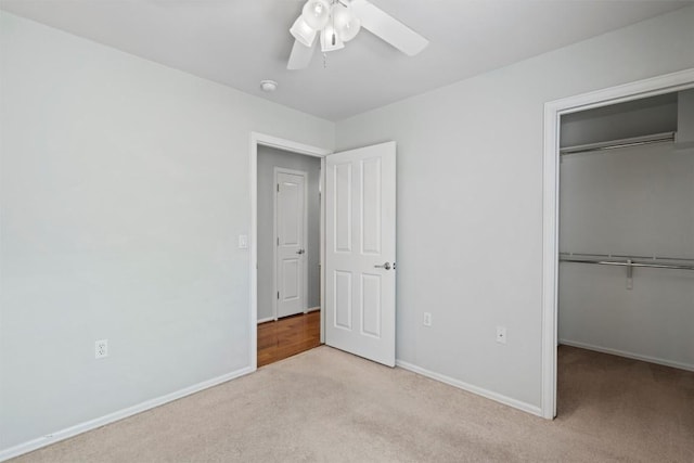 unfurnished bedroom with a closet, carpet floors, baseboards, and a ceiling fan