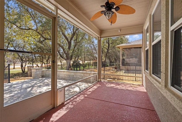 unfurnished sunroom featuring a wealth of natural light and ceiling fan