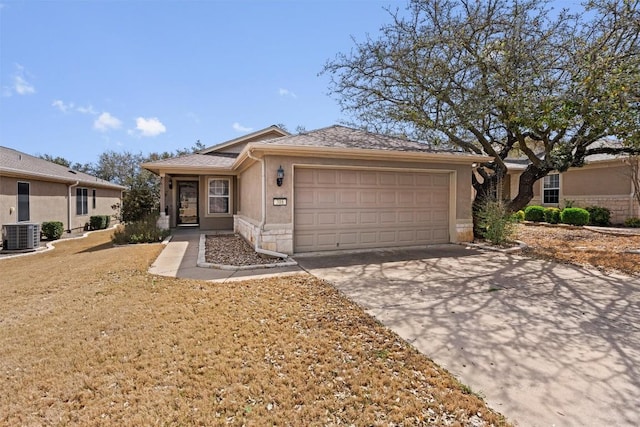 single story home featuring concrete driveway, a garage, central AC, and stucco siding