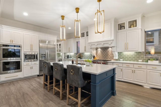 kitchen featuring built in appliances, light wood-style flooring, white cabinetry, and crown molding