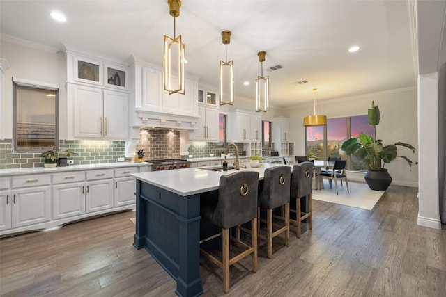 kitchen with a sink, crown molding, and white cabinetry