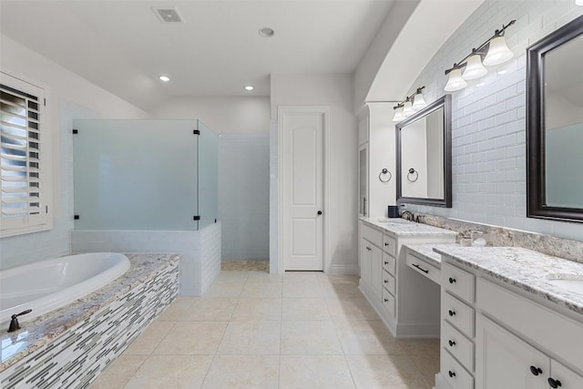 full bath featuring tile patterned floors, visible vents, a garden tub, and vanity