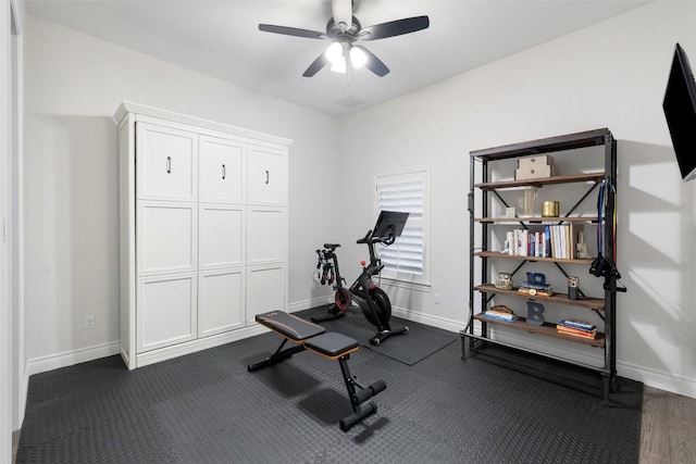 workout area featuring a ceiling fan and baseboards