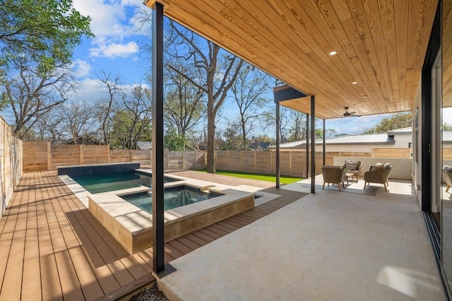 exterior space with an in ground hot tub, a fenced backyard, and a patio